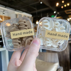 Detalle de pequeñas pinzas mate para el pelo en marrón y crema en cajas claras