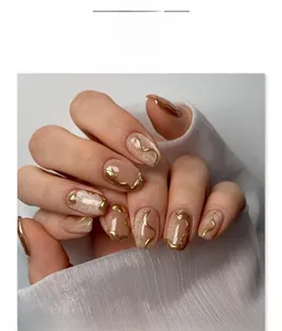 Detail of nude cat-eye press-on nails with champagne gold 3D metallic wave patterns