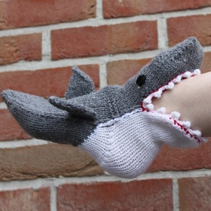 Macro detail of hand-knitted shark-shaped winter socks with realistic grey fins and teeth