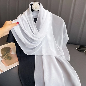 Detailed view of the sheer white chiffon scarf texture with elegant camellia floral accent