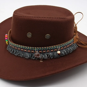 Detail of western cowboy hat with bohemian braided band, gray tassels and retro metal coin