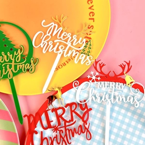 Festive Merry Christmas acrylic cake toppers with reindeer antlers and trees on plates