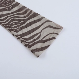 Détail d'une manche en maille transparente avec imprimé zèbre et coutures précises