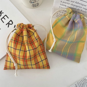 Detail of drawstring fabric pouches with classic plaid patterns and cotton cords