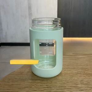 Detail of 330ml mint green borosilicate glass bottle with heat-insulating PP outer shell