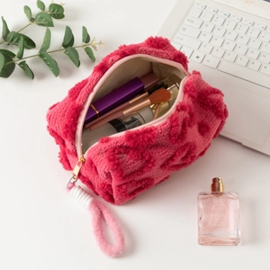 Macro detail of plush pink velvet makeup bag showing storage for brushes and cosmetics