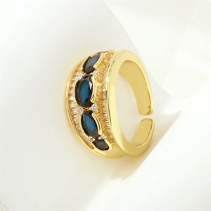 Detailed shot of 18K gold plated X-ring with a blue oval gemstone and white zirconias