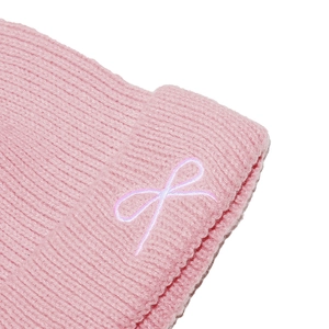 Close-up of pink ribbed knit texture with a delicate embroidered lavender bow detail