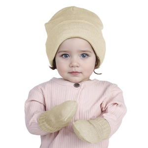 Close-up of baby knitted beanie and mittens set in beige on a sleeping infant