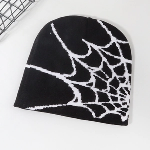 Detailed top view of black knit beanie with white spider web jacquard on white background