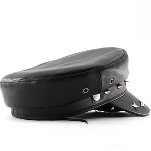 Detail of black faux leather flat cap with silver cone studs and star metal accents
