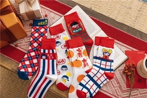 Close-up of five festive red cotton socks with holiday patterns and lucky characters