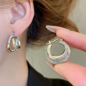 Close-up of sparkling silver double-layer hoop earrings with cubic zirconia on model