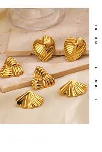 Macro detail of gold geometric earrings with vertical ribbing on a luxury stone background