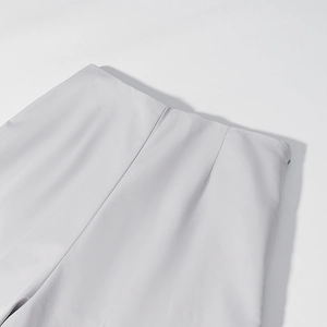 Close-up of light gray trousers showing back waist darts and invisible zipper detail