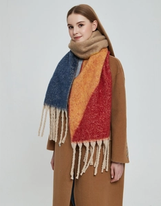 Close-up of thick tassels and colorful patchwork knit texture on women scarf