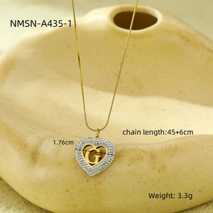 Detailed macro view of heart pendant with zirconia and gold letter G on ceramic