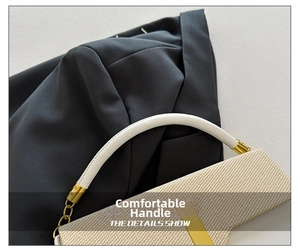 Close-up of white leather handle and gold hardware on woven crossbody box bag