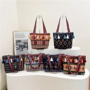 Ethnic woven tote bags with colorful tribal patterns and fringe details on a display