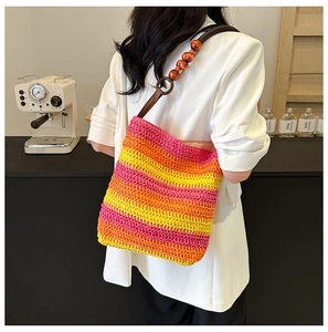 Rainbow woven bucket bag with wood bead strap details on a white blazer model