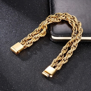 Détail du bracelet gourmette doré avec fermoir plat sur surface texturée sombre