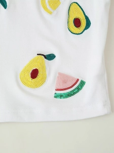 Detailed close-up of sequin fruit embroidery on white ribbed tank top fabric