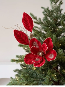 Detail of red velvet Christmas flower with gold sequins on a decorated festive tree