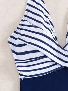 Detail of blue and white striped swimsuit with wrap V-neck and elastic fabric
