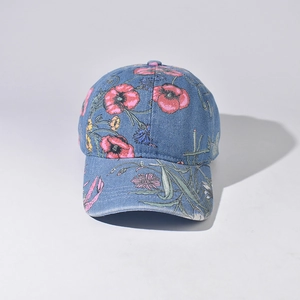 Close-up of denim baseball cap featuring vibrant red floral patterns and retro texture