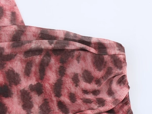 Detail view of breathable red and black tie-dye mesh fabric showing textile texture