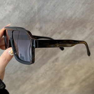 Detailed side view of oversized black sunglasses with wide temple design and thick frames