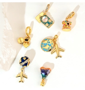 Detailed macro shot of gold travel charms with zircon stones and enamel finish