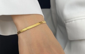 Close-up of gold snake chain bracelet on wrist with a minimalist fashion style