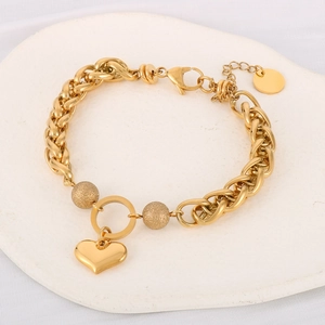Close-up of golden stainless steel heart pendant bracelet with matte beads on a tray