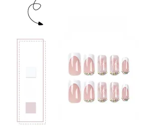Detail of French press-on nails with white marble patterns and sparkling rhinestones