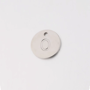 Macro shot of 12mm stainless steel mirror finish round charm with letter O engraving