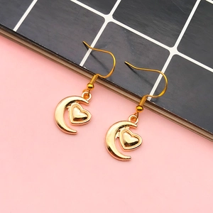 Golden crescent moon and heart charm earrings set on a stylish checkered background