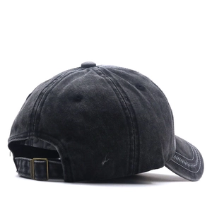 Détail d'une casquette en coton délavé avec finition vintage et boucle en métal réglable