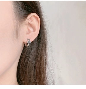 Close-up of S925 sterling silver hoop earrings with a vintage diamond-set cross pendant