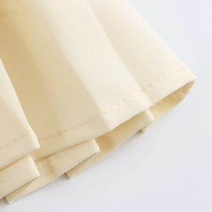 Completo elegante in tweed con gonna a pieghe bianco crema e dettagli di cucitura