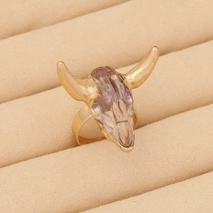 Macro shot of bohemian golden bull head ring with iridescent inlay on a velvet tray
