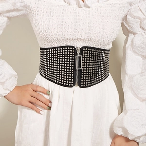 Retro black wide corset belt with silver rivets and front zipper over a white dress