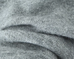 Gros plan sur la texture du tricot gris révélant les fibres douces et les détails du tissage