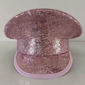 Close-up of sparkling pink sequins on the crown and brim of a party captain hat