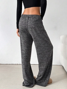 Detail showing high-waisted gray waffle knit trousers and elastic waistband from back