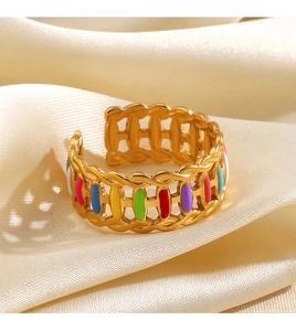 Detail of colorful enamel gold ring showing intricate woven texture on satin fabric