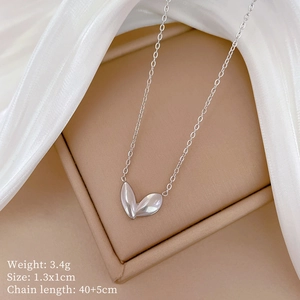 Macro shot of silver bud leaf pendant with size specs on elegant white silk background