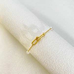 Gold stainless steel bracelet with horseshoe buckle, heart motif, and elegant pearls