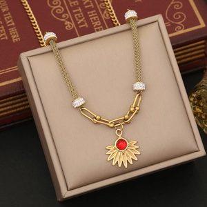 Elegant gold heart sunburst pendant necklace with red gem on vintage jewelry box
