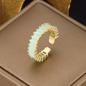 Macro shot of an adjustable gold-plated ring with rectangular mint green zircon stones